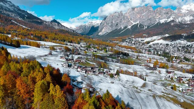 Aerial drone view of valley, snowy villages, autumn forest, Dolomites mountains Italy. High quality 4k footage