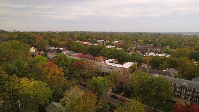 Aerial flyover Clayton neighborhood with apartment buildings and trees in Autumn.