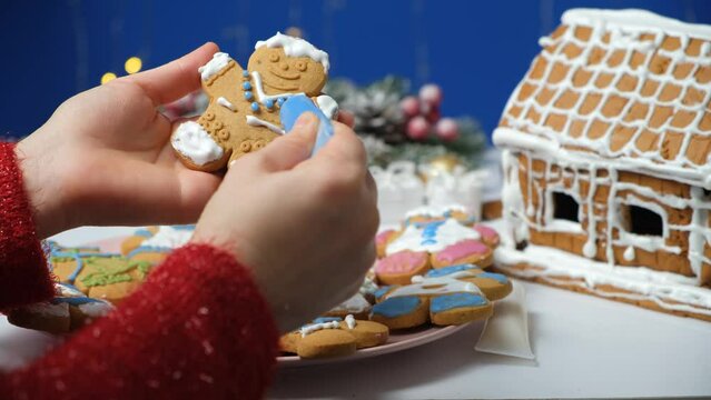 Decorating Christmas gingerbread with sugar multicolored icing.