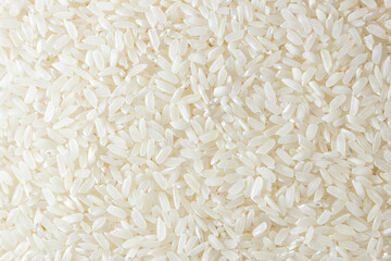 Dry Uncooked White Rice Background - Top View, Flat Lay. Scattered Raw Long Grain Rice. Asian Cuisine and Culture. Healthy Eating Ingredients. Diet Food