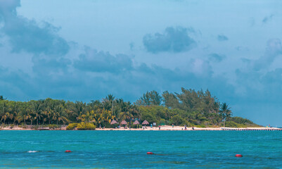 Tropical Caribbean beach people parasols fun Playa del Carmen Mexico.