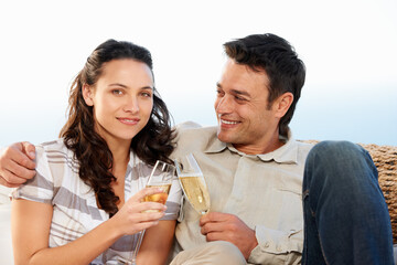 Couple, drinking champagne and toast for celebration and good news on honeymoon, announcement and love. Looking at wife, smile and happy with romantic gesture, bonding together and anniversary