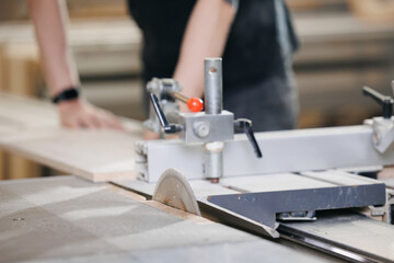 Closeup of wood cut table with electric circular saw for chipboard for furniture production. Professional carpenter cutting wooden board at sawmill