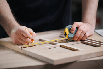 Banner carpentry workshop industry. Closeup craftsman hand marking the wooden kitchen furniture