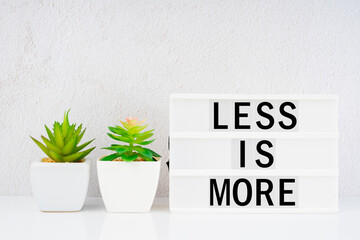 The lightbox displaying the words "Less is more" with and plants. Zero waste concept.