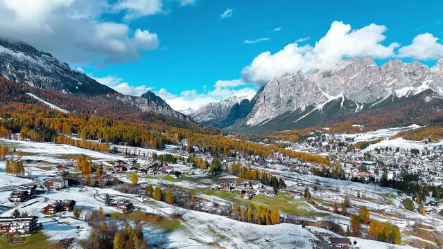 Aerial drone view of valley, snowy villages, autumn forest, Dolomites mountains Italy. High quality 4k footage