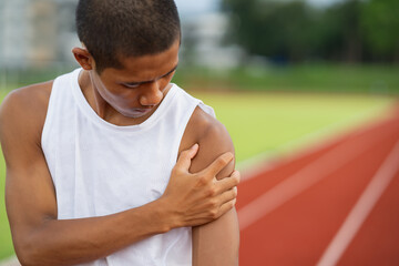 Athletes sport man runner wearing white sportswear to sitting feeling pain in his shoulder after...