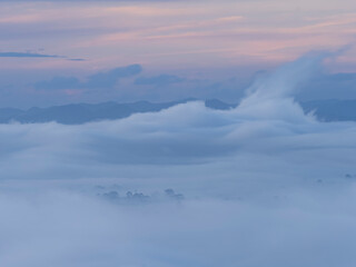 Morning mist flows through the mountains.