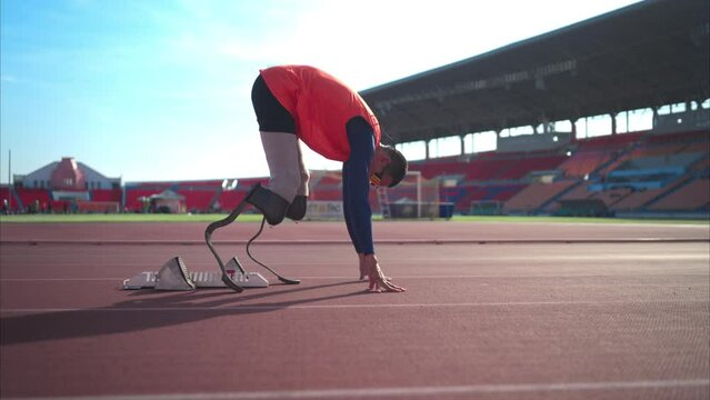 Disabled athletes prepare in starting position ready to run on stadium track