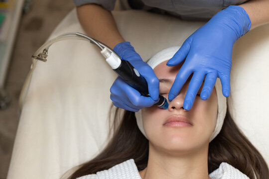 Woman receiving hydrafacial treatment in beauty salon