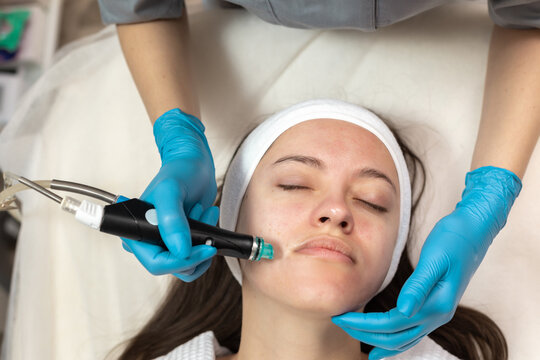 Woman receiving hydrafacial treatment in beauty salon