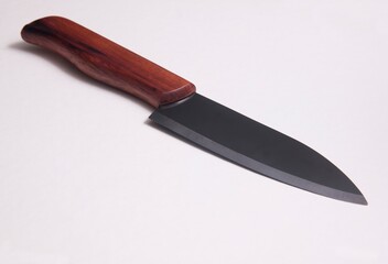 A Ceramic Knife on a wooden plate