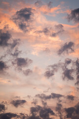 Colorful clouds in sky during sunset. Vertical shot of bright vibrant clouds in evening sky