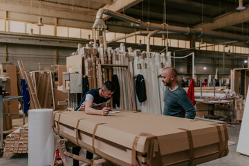 Two diligent workers collaboratively prepare the final wooden product for plasma treatment, ensuring impeccable quality and craftsmanship as they ready it for the global market, exemplifying precision