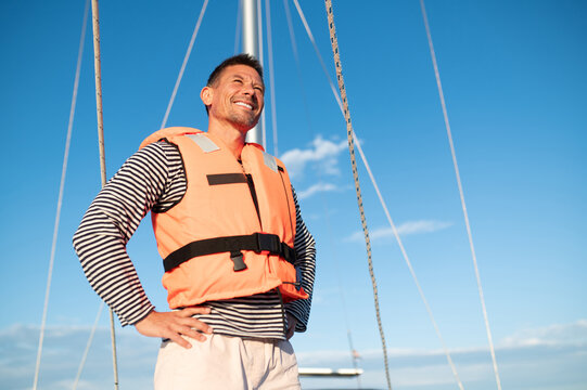 Mature man in a life jacket on a yach feeling good