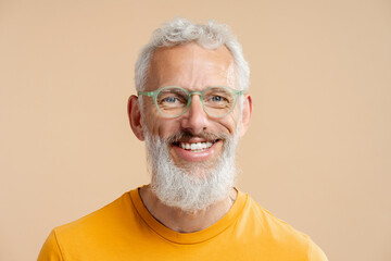 Closeup portrait handsome smiling mature man with white teeth wearing stylish hipster eyeglasses looking at camera isolated on background. Happy gray haired bearded male after barbershop service