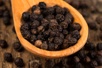 black pepper on wooden spoon