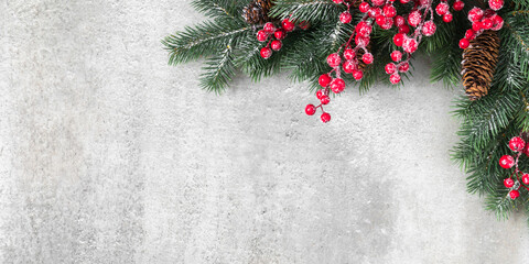 Christmas holiday composition. Christmas fir tree branches, red berries on gray background. Xmas,...