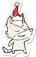 friendly hand drawn distressed sticker cartoon of a wolf wearing santa hat