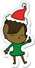 hand drawn sticker cartoon of a squinting girl wearing santa hat