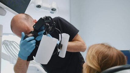 Dentist orthodontist taking picture of patient teeth for examination. Young woman treating her teeth in professional stomatology clinic. Healthcare. Medicine.