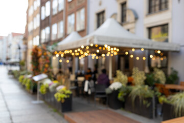 Blurred image of the terrace interior with garland lights, warm light source. Abstract image