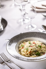 Italian Spaghetti Algio e Olio with Garlic Parmesan and chili peppers on restaurant festive table