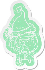 happy quirky cartoon distressed sticker of a astronaut wearing santa hat