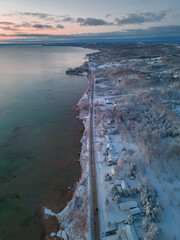 Naklejka premium Winter's Serene Embrace: A Breathtaking Aerial View of Snow Covered Suttons Bay in Northern Michigan