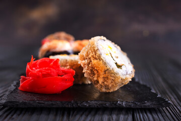 Sushi roll with salmon, smoked eel, avocado, cream cheese on black background. Sushi menu. Japanese food.