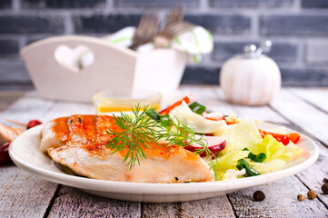 Grilled chicken breast, fillet and fresh vegetable salad of lettuce, arugula, spinach, cucumber and tomato.