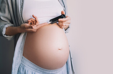 Gestational diabetes test during pregnancy. Pregnant woman checking blood sugar level with glucometer. - obrazy, fototapety, plakaty