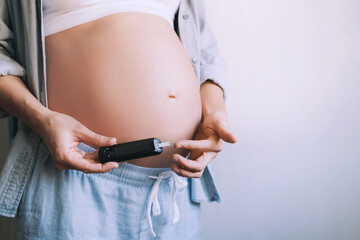 Gestational diabetes test during pregnancy. Pregnant woman checking blood sugar level with glucometer. - obrazy, fototapety, plakaty