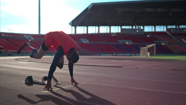 Disabled athletes prepare in starting position ready to run on stadium track