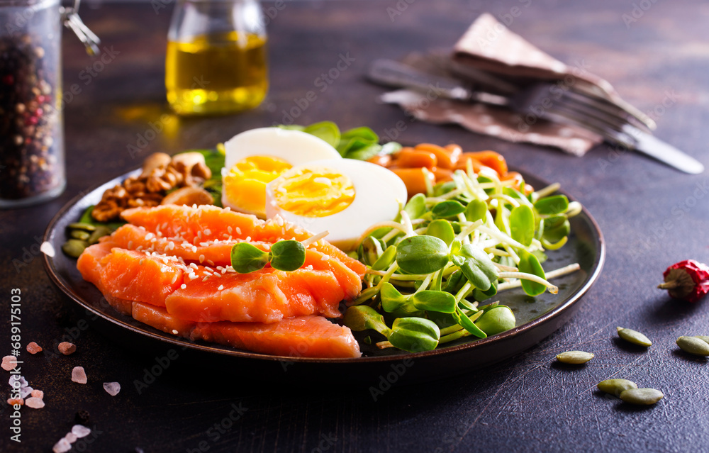 Poster Keto diet breakfast. Salt salmon salad with greens, cucumbers, eggs and avocado.