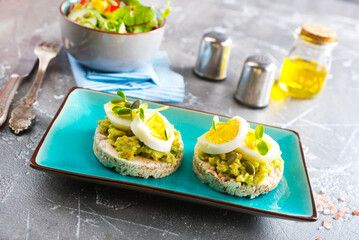 Healthy tasty toast with avocado, white cheese and boiled egg on plate