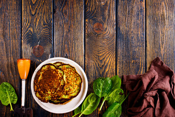 Homemade spinach pancakes on wooden background.
