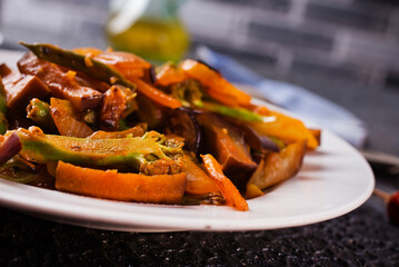 Chopped cooked vegetables on dark background, Traditional ratatouille with zucchini, bell pepper and eggplant