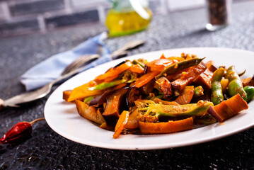 Chopped cooked vegetables on dark background, Traditional ratatouille with zucchini, bell pepper and eggplant