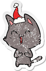 happy hand drawn distressed sticker cartoon of a cat wearing santa hat