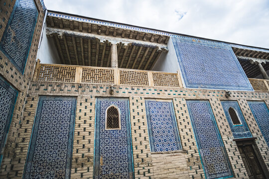 Facades of buildings covered with ceramic mosaic tiles, with wooden columns in the historical city of Khiva in Khorezm