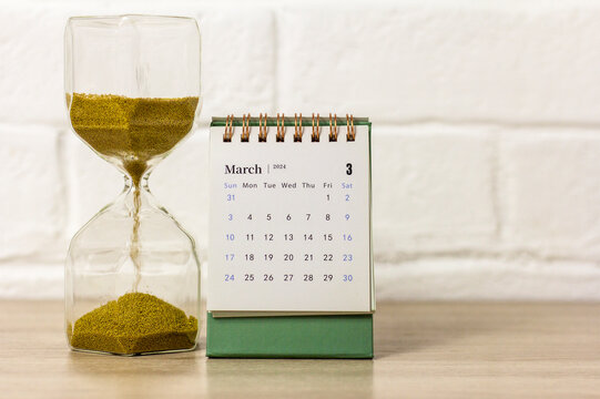 A desk calendar for March 2024 and a clock on the table with a place to copy.