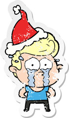 hand drawn distressed sticker cartoon of a crying man wearing santa hat