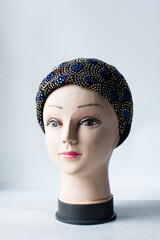 black turban with rhinestones on a mannequin head, black fashion turban with diamante on a white...