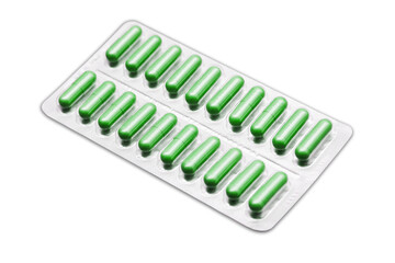 Metal tablet blister. Green pills medicine. Silver shiny blister with drugs. Green color capsules isolated on white. Cutout medicament isolated on white. Aluminum pills blister.