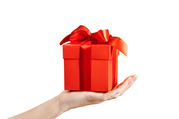 A woman's hand holds a gift with a red bow on a white background