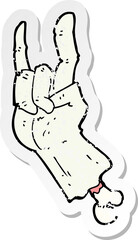 retro distressed sticker of a cartoon zombie hand making rock symbol