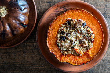 Great pumpkin baked with a filling close up. Stuffed roasted orange pumpkin, whole baked, filled with a tasty mixture of rice, raisins and spices