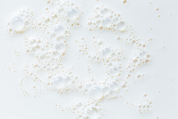 Macro milk close-up texture,Over head close up full frame background detail view of frothy white milk creating bubbles, indoors. Macro still life view of liquid milk drink