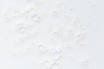 Fototapeta na wymiar Macro milk close-up texture,Over head close up full frame background detail view of frothy white milk creating bubbles, indoors. Macro still life view of liquid milk drink